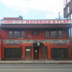 a red building with a sign that says where it's at maverick's flat