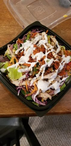 a salad in a plastic container with dressing on top