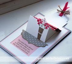 a close up of a greeting card with flowers in a vase on the front and bottom