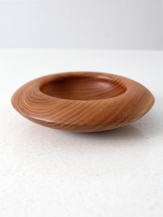 a wooden bowl sitting on top of a white table