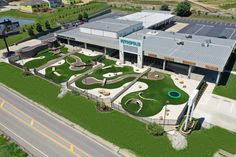 an aerial view of a building with artificial grass in the front and landscaping around it