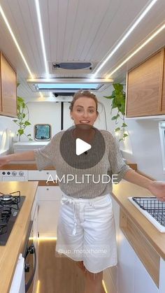 a woman is standing in the kitchen with her arms spread out and looking at the camera