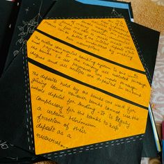 several pieces of yellow paper with writing on them sitting next to markers and pencils