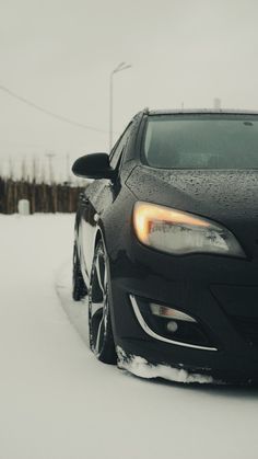 a black car is parked in the snow