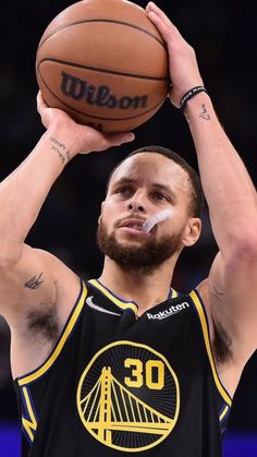 a man with a beard holding a basketball in his right hand and looking up at the sky