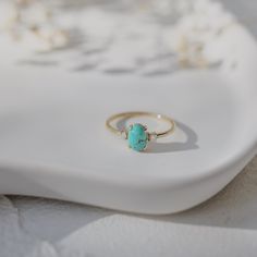 This elegant natural turquoise engagement ring is a perfect blend of unique charm and timeless beauty. The vibrant 4.6 mm oval turquoise takes center stage, flanked by two sparkling diamonds that add a touch of classic brilliance. Material: 14-karat solid gold Gold Colors: Available in yellow, rose, and white gold Turquoise Size: 4.6 mm oval-cut natural turquoise Diamond Details: Two round-cut diamonds, 0.06 ct total weight, G color, VS clarity Design: Turquoise center stone with diamond accents on either side This ring is an exquisite choice for those seeking a distinctive yet sophisticated engagement ring Turquoise Engagement Ring, Turquoise Ring Engagement, Turquoise Gold Ring, Ring With Diamond, Box Making, Solid Gold Rings, Perfect Engagement Ring, Custom Engagement Ring, Natural Turquoise