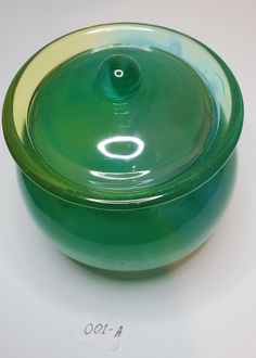 a green bowl sitting on top of a white table