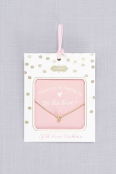 a card with a gold heart on it and a pink ribbon hanging from the front