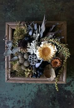 an arrangement of flowers in a wooden box