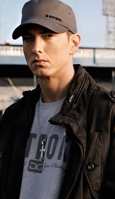 a young man wearing a hat and looking at the camera