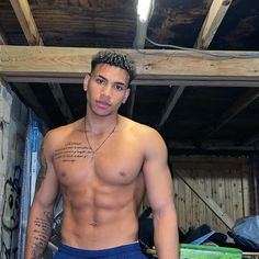 a man with no shirt standing in a garage