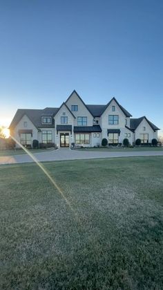 a large white house sitting on top of a lush green field