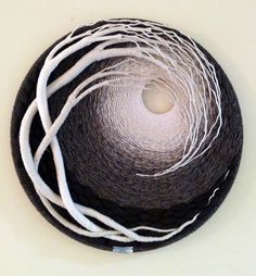 there is a black and white bowl with some white thread on the inside of it