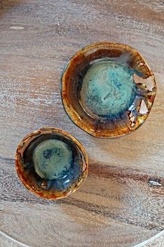 two bowls sitting on top of a wooden table