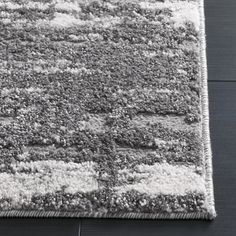 a gray and white rug on the floor