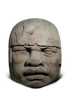 a stone head with eyes and nose is shown in the dark, it appears to be an old man's face