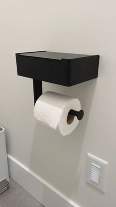 a toilet paper dispenser mounted to the wall