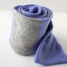 a roll of blue and grey fabric sitting on top of a white table