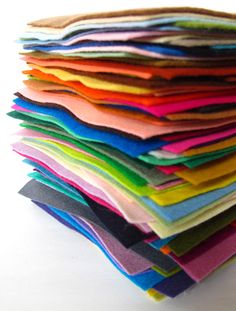 a stack of different colored fabrics sitting on top of each other in front of a white background