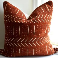 a brown and white pillow sitting on top of a window sill