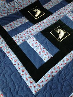 a blue quilt with black and gold appliqued squares on it's sides