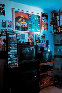 a living room filled with lots of different types of electronic equipment and pictures on the wall