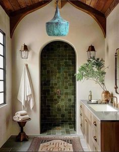 a bathroom with green tile and wooden ceiling