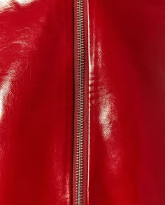 a close up view of the zippers on a red leather jacket