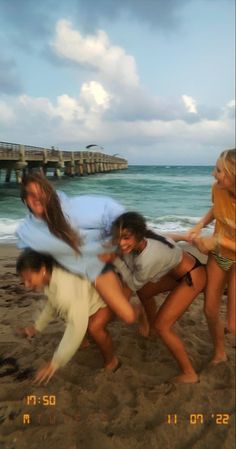 four people on the beach posing for a photo