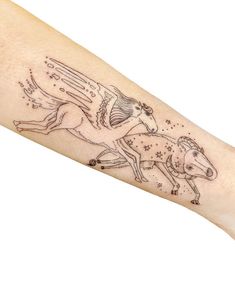 a woman's arm with a tattoo on it that has an image of a horse and stars