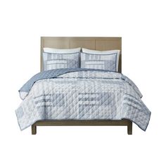 a bed with blue and white quilts on it