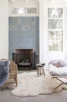 a living room with a fireplace, chair and rug