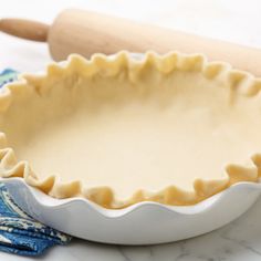 an uncooked pie crust with a rolling pin next to it