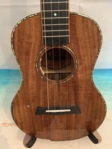 an acoustic guitar sitting on top of a wooden stand