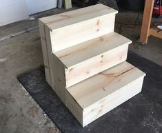 three wooden boxes stacked on top of each other in a room with tools and supplies