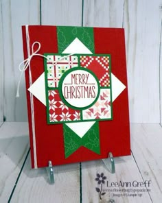 a red and green christmas card sitting on top of a wooden table