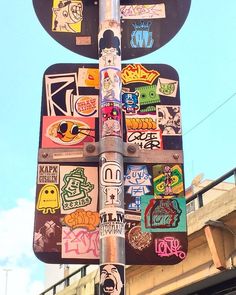 a street sign with many stickers on it