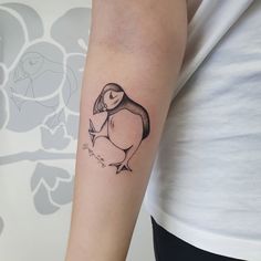 a woman with a penguin tattoo on her arm