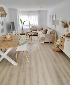 an instagram photo of a living room with white furniture and wood flooring on the walls