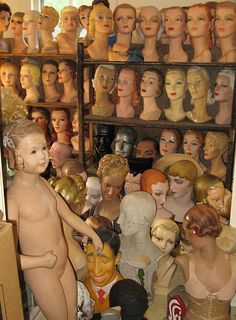 there are many mannequins in the room and one is holding a doll