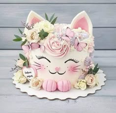 a cake decorated with flowers and a cat's face on top of a plate