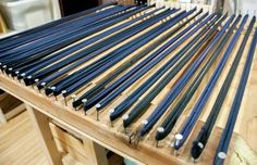 a wooden table topped with lots of blue and black rods on top of wood flooring