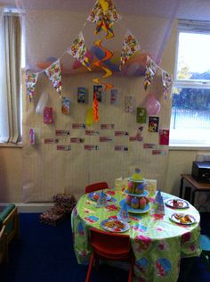 a child's birthday party with balloons and streamers hanging from the ceiling over a table