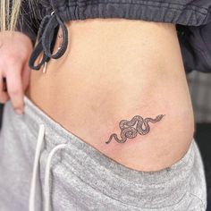 a woman's stomach with a tattoo on it that has a snake in the middle