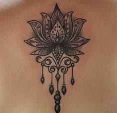 the back of a woman's shoulder with an intricate tattoo design on her chest