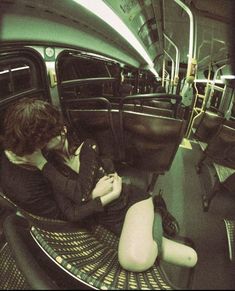 a woman is sitting in the seat of a bus and looking at her cell phone