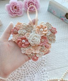 an ornament with flowers and pearls on it sitting next to some other items