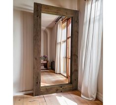 a large mirror sitting on top of a wooden floor