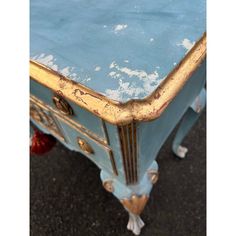 an old blue table with gold trimming