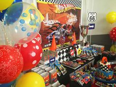 a table filled with lots of balloons and cake on top of it's sides